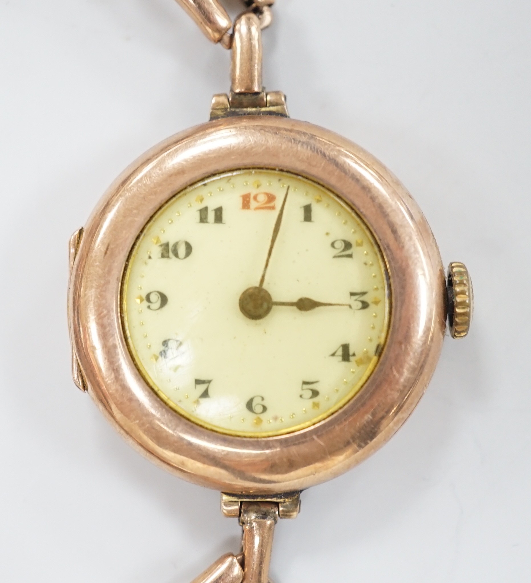An early 20th century 9ct gold Rolex manual wind wrist watch, with Arabic dial, case diameter 27mm, on an expanding yellow metal bracelet, gross weight 22.1 grams.